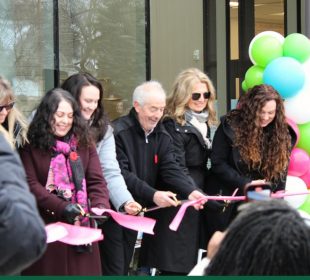 A group of people participate in the ribbon-cutting ceremony at the kikaskihtânaw Centre.