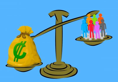 An image of a scale that’s weighing a bag of money and a group of people, the bag of money outweighing the group of people.
