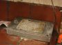 A Poulin’s Pest Control device and sticky trap sit underneath a sink.