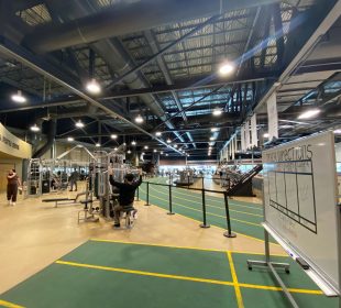 A photo of the UR Fitness and Lifestyle Centre, from the entrance. Parts of the track and the weight machines are visible.