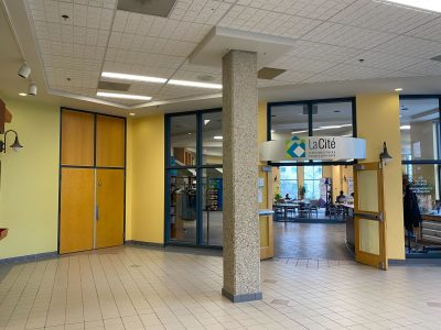 A photo of the outside of La Rotonde in La Cité. There are a few people inside it, but mostly it is empty.