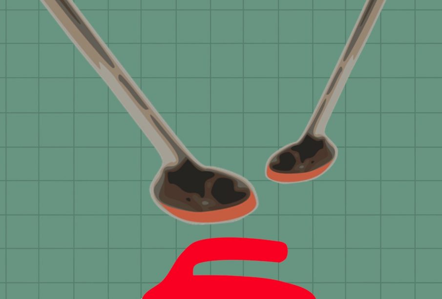 A red curling rock with two curling brooms above it.