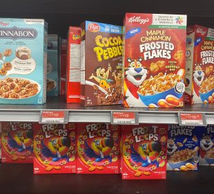 A photo of a cereal isle in a grocery store. In the photo are Kellog’s cereal brands, priced at “3 for $10.”