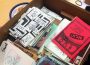A cardboard box filled with books, pamphlets, and zines of all colours.