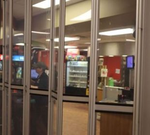 Cindy Gates is pictured preparing to open the Lab Café from behind its partially transparent storefront gates.