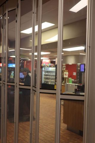 Cindy Gates is pictured preparing to open the Lab Café from behind its partially transparent storefront gates.