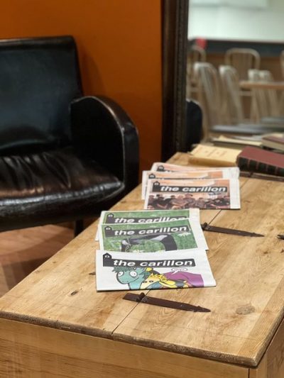 A photo of a table in a coffee shop, with some issues of the Carillon laid out.
