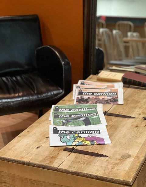 A photo of a table in a coffee shop, with some issues of the Carillon laid out.