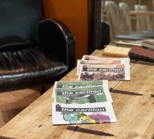A photo of a table in a coffee shop, with some issues of the Carillon laid out.