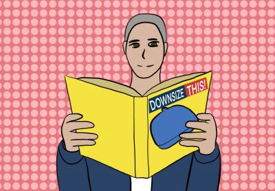 A person sits reading Michael Moore’s book Downsize This!