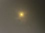 A photo of the April 8, 2024 solar eclipse taken through specialized eclipse-viewing glasses. The sun looks like a heart.