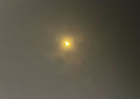 A photo of the April 8, 2024 solar eclipse taken through specialized eclipse-viewing glasses. The sun looks like a heart.