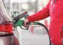A person’s arm is shown filling up a car tank with fuel.