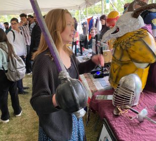 A photo from the U of R’s Welcome Week. In it, a student holds a replica weapon that looks like a rapier.