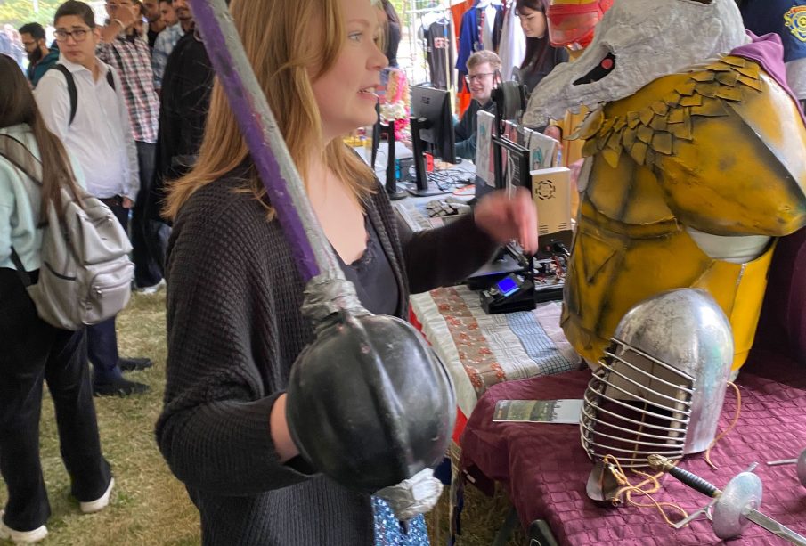 A photo from the U of R’s Welcome Week. In it, a student holds a replica weapon that looks like a rapier.