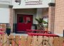 The entrance to Tommy’s Speakeatery, with a graphic of a head’s silhouette and a bright red fedora