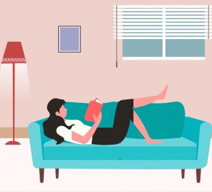 A person lying on a couch, reading a book.