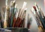 A photo of countless dirty paint brushes.