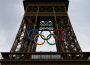A photo of the Eiffel tower during the 2024 Paris Games. The tower has the 5 Olympic rings logo hung from it.