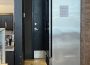 A photo showing a fridge, half-blocking the entrance to the public washroom.