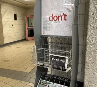 A photo of a Carillon newspaper stand. Some issues are folded and stocked.