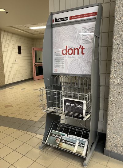 A photo of a Carillon newspaper stand. Some issues are folded and stocked.