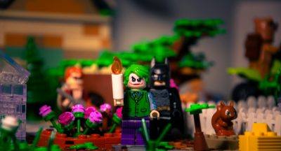 Lego action figures of Batman and The Joker, with several other figures in the background.