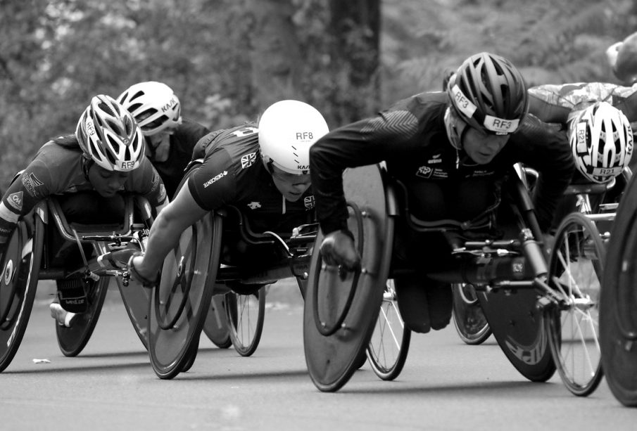 A photo of athletes in racing wheelchairs competing against each other.