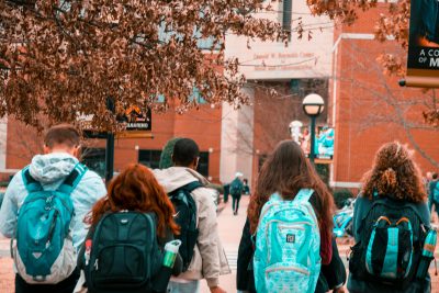 A photo from behind of a number of students walking in a group