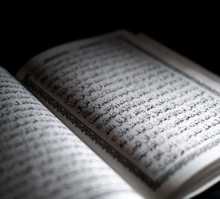 A photo of the Quran, open to a page.