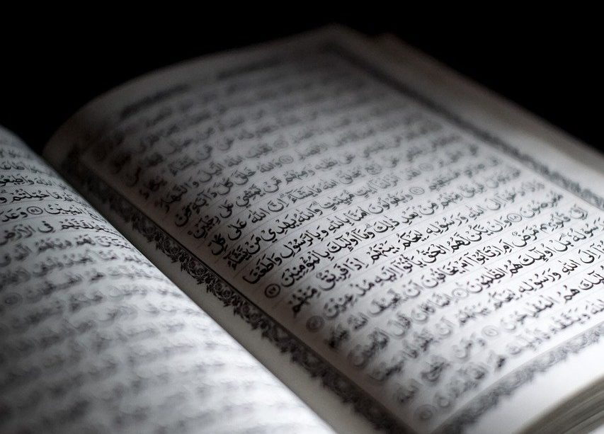 A photo of the Quran, open to a page.