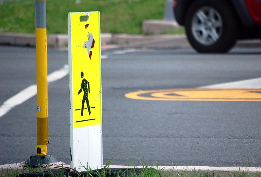 A pedestrian crossing sign on the side of a road.