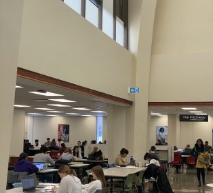 A photo of the Archer library main floor, with people studying at desks.
