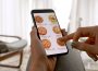 A hand holding a phone screen, open to a food delivery app.