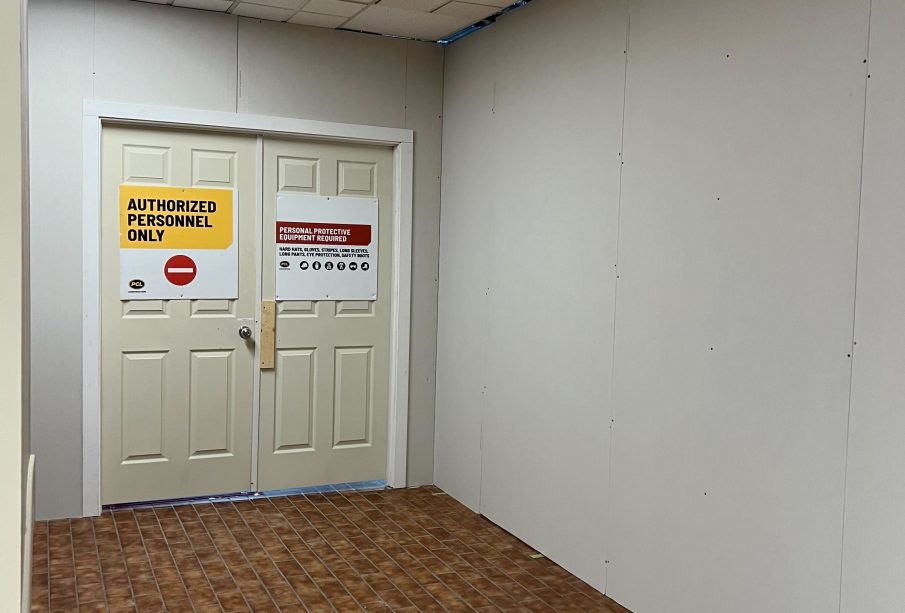 A sign is posted on a temporary door reading “authorized personnel only” walls are covering the space where the lab cafeteria is.