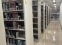 Stacks of books are shown on shelves in Archer Library