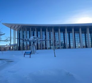 The RCMP Heritage Centre surrounded by snow and a low sun.