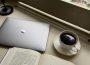 A photo showing a cup of coffee, an open book and a laptop.