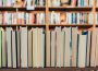 A row of books in a library with the closed pages front-facing.