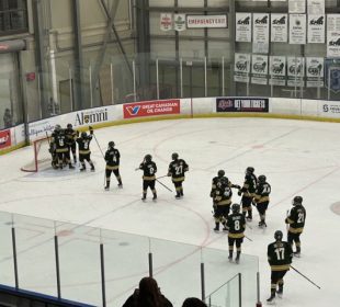 The University of Regina women’s Cougars hockey team celebrating their win on the ice.