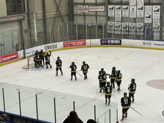 The University of Regina women’s Cougars hockey team celebrating their win on the ice.