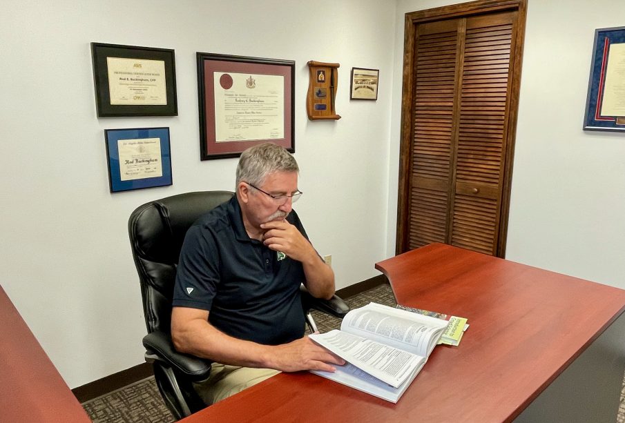 Rod Buckingham sitting at his desk in his Regina office