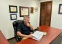 Rod Buckingham sitting at his desk in his Regina office