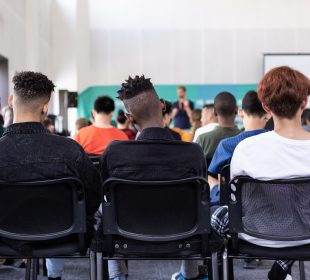 View of a classroom full of students from the back