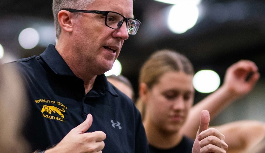 Cougars women’s basketball head coach Dave Taylor stands strategizing with and encouraging the team.