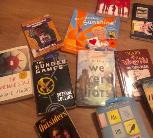This photo shows a spread of books laid out on the floor. These books range from children’s books, all the way to young adult novels. Some of the classics listed include Diary of A wimpy Kid, The Hunger Games, and The Handmaid’s Tale.