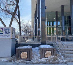 A photo of the main entrance of the Regina Public Library Central Branch. The RPL logo is visible next to the stairs leading to the entrance.