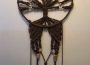 A beautiful macramé craft hanging up on a wall.