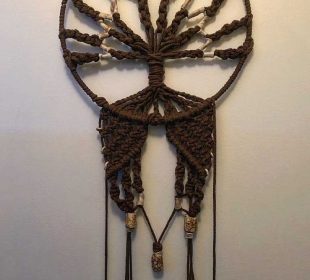 A beautiful macramé craft hanging up on a wall.