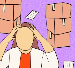 A person with both hands on their head, with some papers strewn around the floor and boxes in the background.